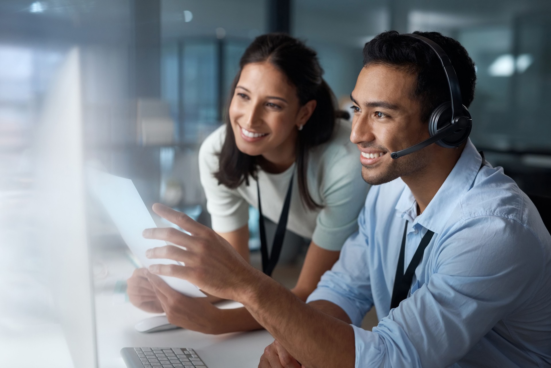 Shot of a young man and woman using a computer while working in a call centre